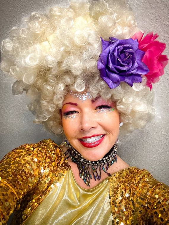 Madelyn Greco in a white curled wig and gold sequins