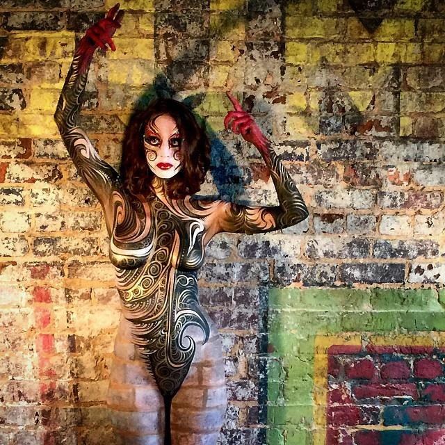 Bodypainted model against a painted brick wall