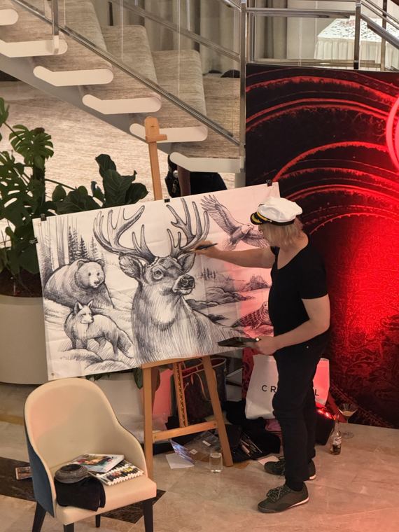 Scott Fray painting a wildlife banner on an easel