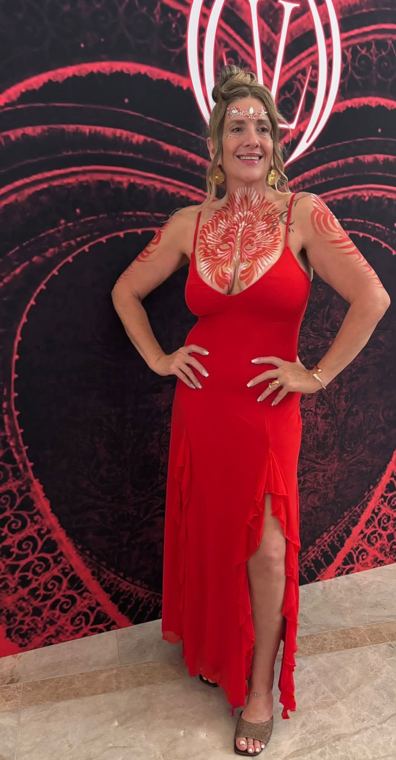 A guest in a red dress with a red painted design across her chest