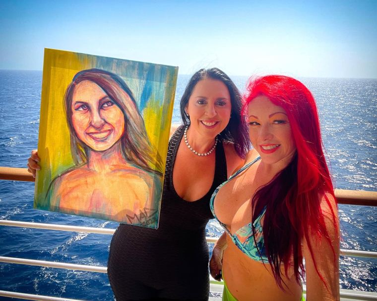 Madelyn Greco and a guest with a portrait on a ship’s balcony