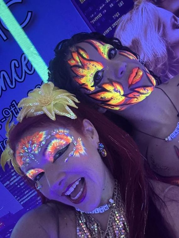 Two guests with glowing faces at a neon party