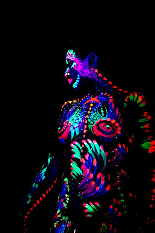 Seated figure glowing in fluorescent swirls