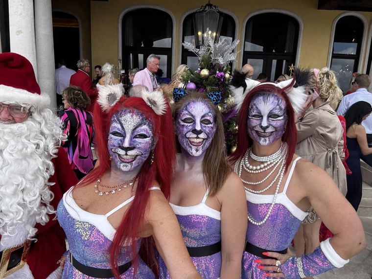 Three guests in matching cat facepainting with Santa