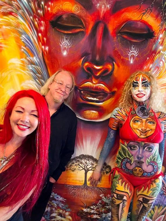 Scott and Madelyn beside a large painted mural face