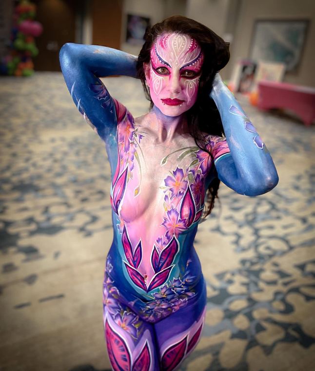 Guest bodypainted in violet and blue floral patterns
