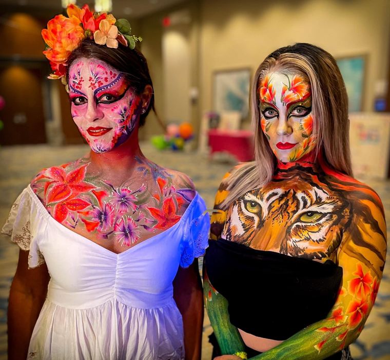 Two guests with floral and tiger facepainting