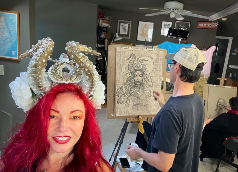 Scott Fray drawing a portrait at an easel while Madelyn Greco sits for it