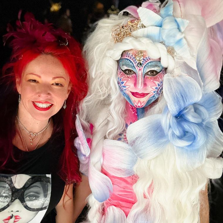 Madelyn Greco beside a guest with a floral mask design
